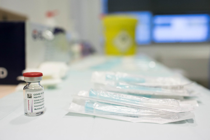 Fotografía que muestra, a la izquierda, un frasco de vacuna contra el covid-19, y a la derecha, envoltorios de productos sanitarios.